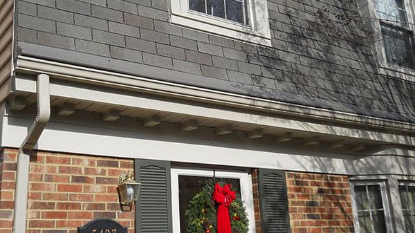 Brick front home with white gutters.